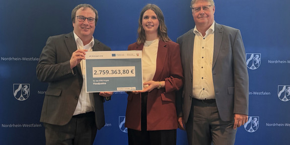 Funding Approval Awarded for the FloodJustice Research Project, from left to right: Minister Oliver Krischer, Marisa Fuchs (TU Dortmund University), Arno Hoppmann (Water Association Eifel-Rur) Funding Approval Awarded for the FloodJustice Research Project, from left to right: Minister Oliver Krischer, Marisa Fuchs (TU Dortmund University), Arno Hoppmann (Water Association Eifel-Rur)